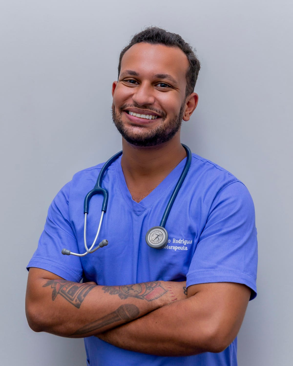Example care team member: smiling professional in blue scrubs with a stethoscope.