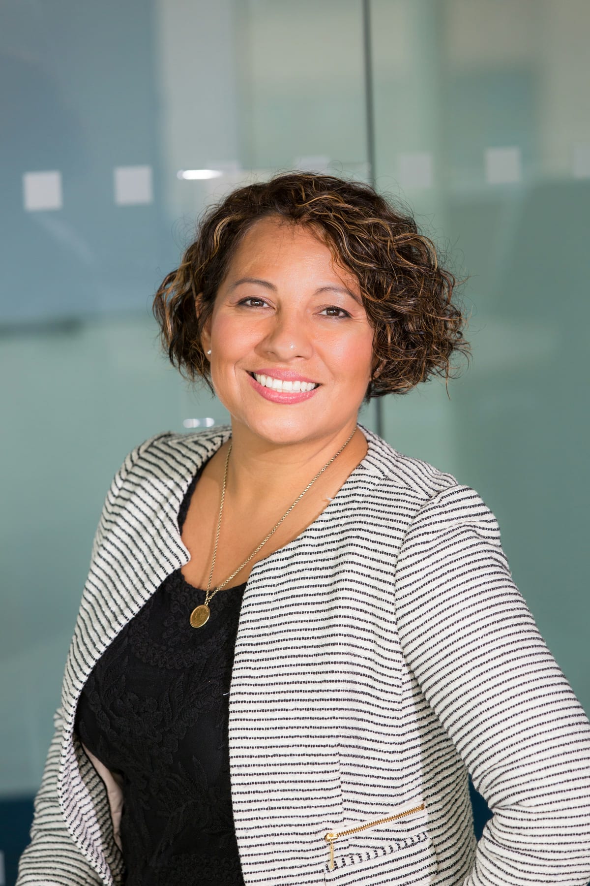 Example care team member: smiling professional in a striped blazer.